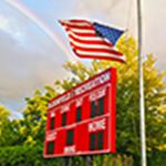American flag flying over a scoreboard